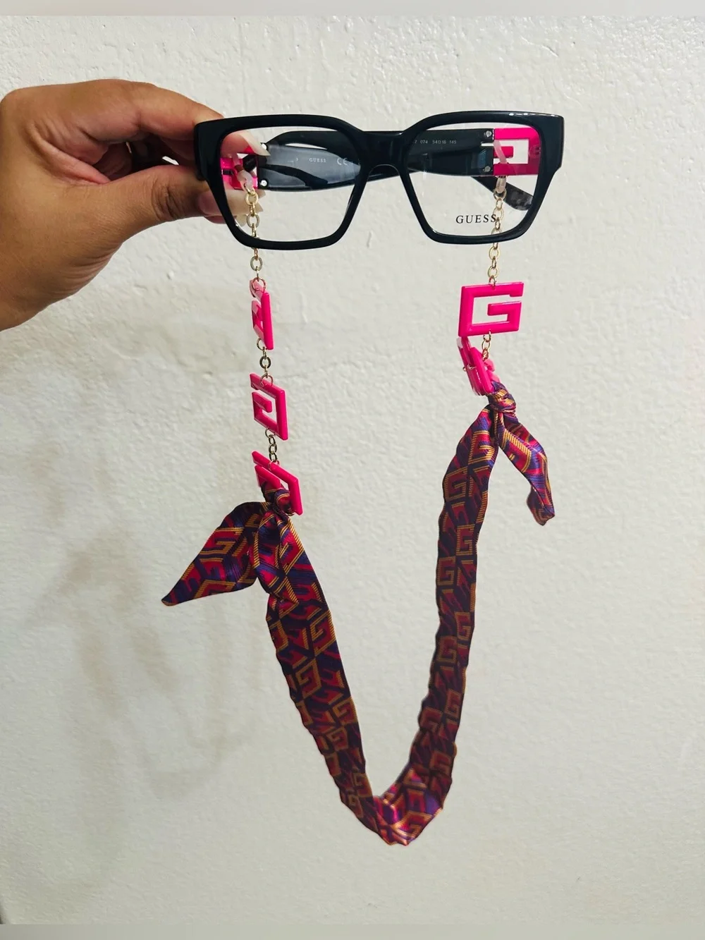 GUESS Black Glasses Chain with Hot Pink Logo Accents and Patterned Ribbon